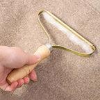Hand holding a metal squeegee over a textured surface