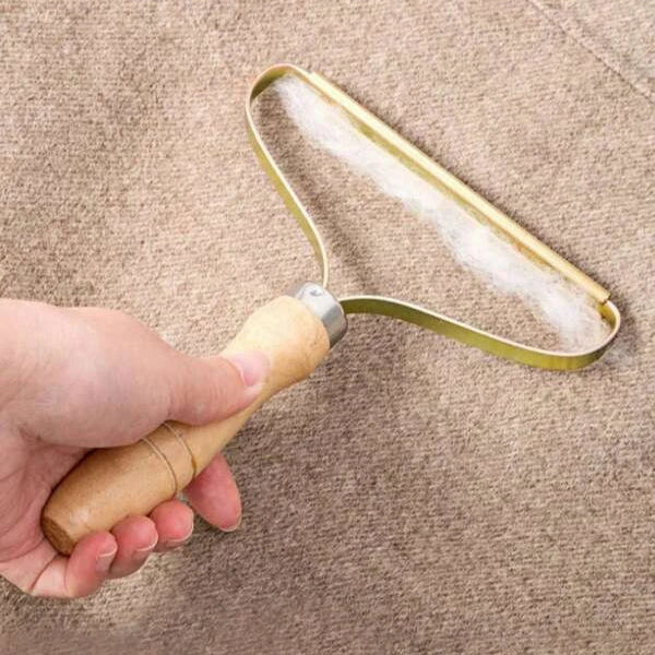 Hand holding a metal squeegee over a textured surface