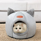 A white and gray cozy cat cave with a cat peeking out from the opening.