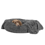 Dog lying on a fluffy gray pet bed against a white background