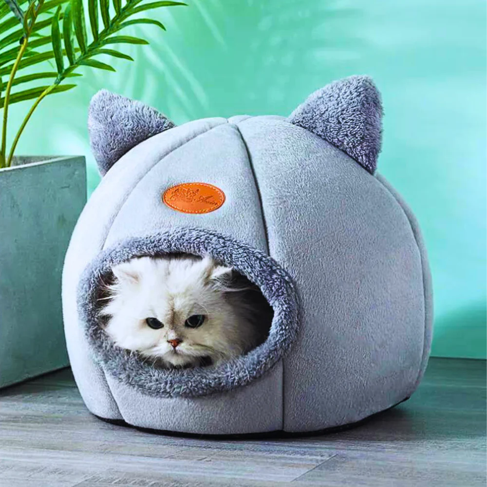 A blue and sky blue cozy cat cave with a cat peeking out from the opening.